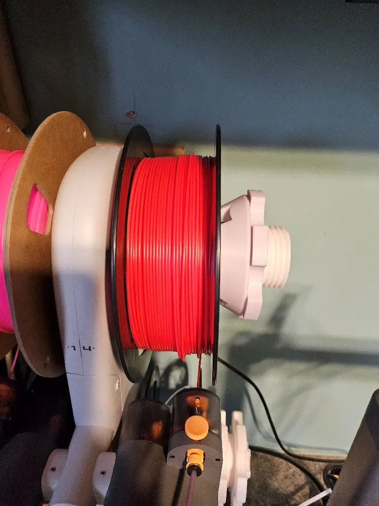 A red wire on a white objectDescription automatically generated