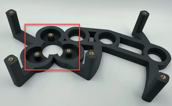 A black plastic object with holesDescription automatically generated