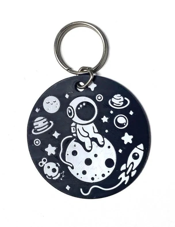 Astronaut seats on the moon keychain
