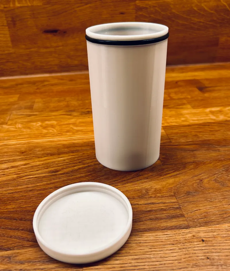 Round container with a lid clamped onto a gasket