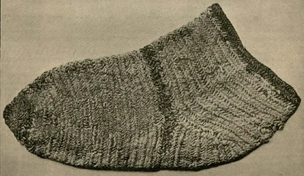 a sock of undyed wool with a red and a brown stripe, found in Saqqara, made in the 6th century
