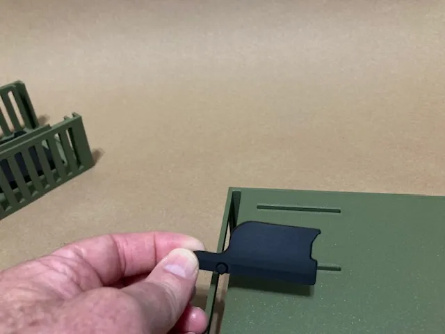 A hand holding a small black object

Description automatically generated