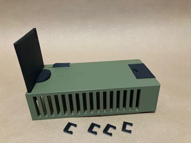 A green rectangular object with black corners
Description automatically generated