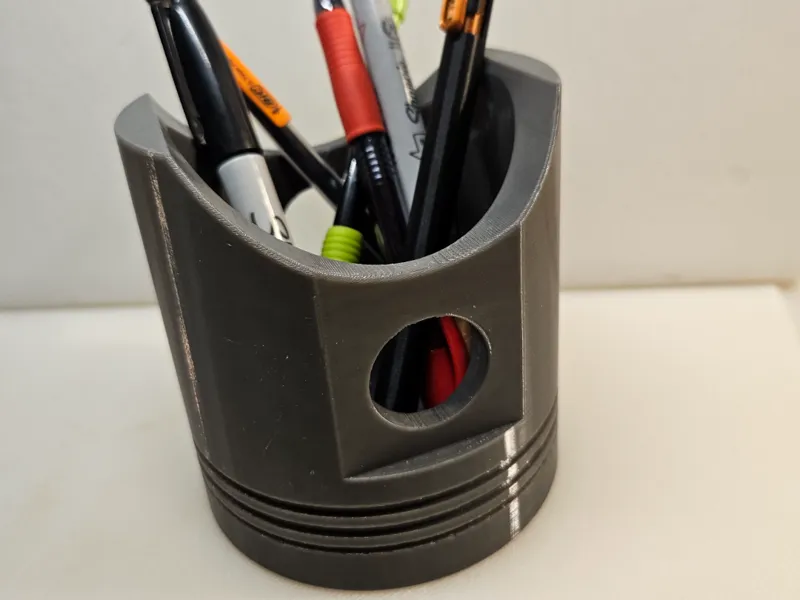 Piston head pen holder