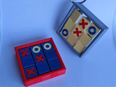 A portable tic-tac-toe keychain that doesn't require storage for game pieces (no AMS, no hardware)
