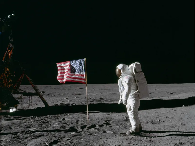 Astronaut beside deployed U.S. flag