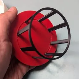 A hand holding a red and black object

Description automatically generated