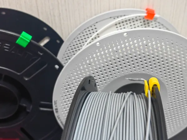 Pince de bobine améliorée pour plateau porte-bobine