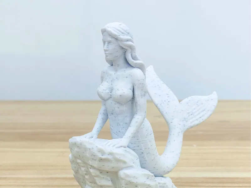“岩石底座上的优雅美人鱼雕塑”