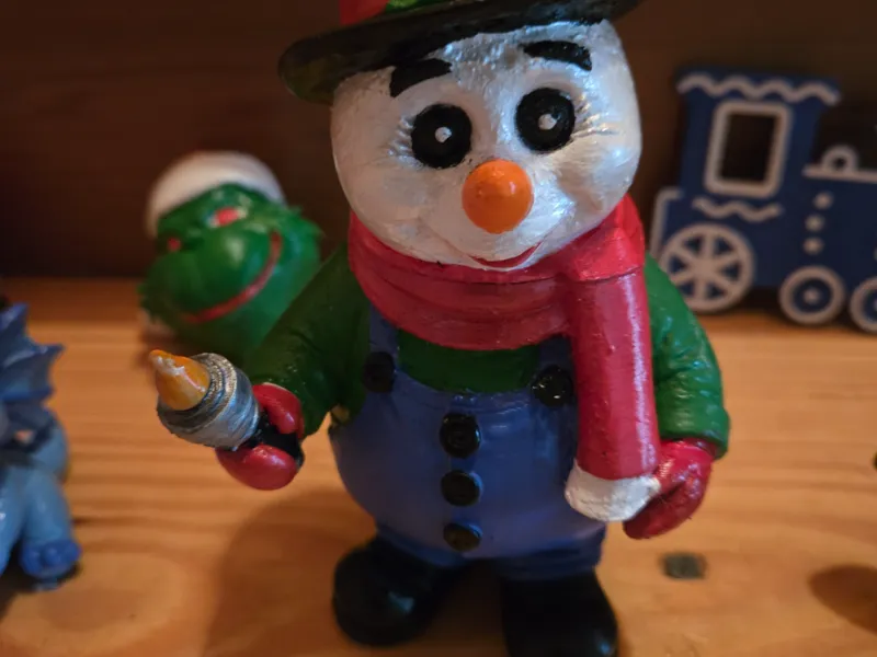 Snowman with Top Hat and Scarf Holding Lantern