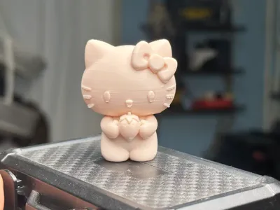 A Hello Kitty holding a strawberry ornament desktop figurine