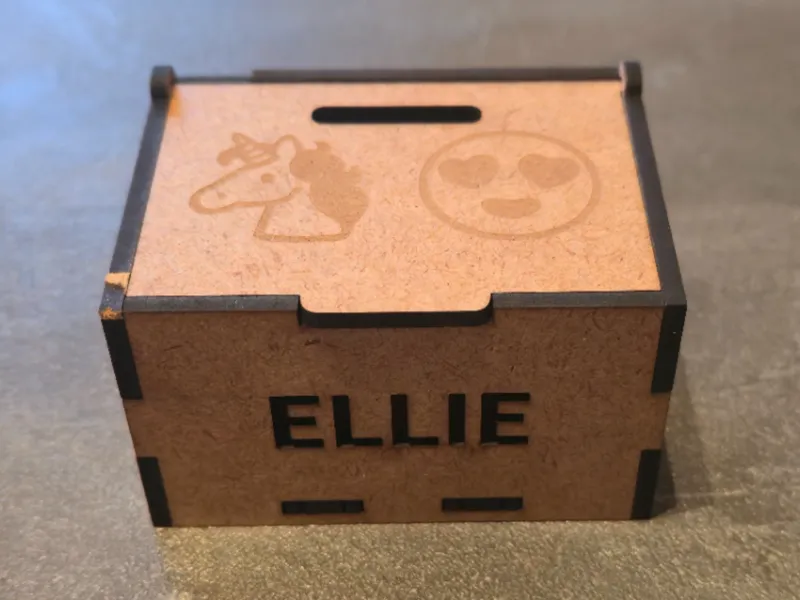 Box with name, smiley and unicorn on top cover.