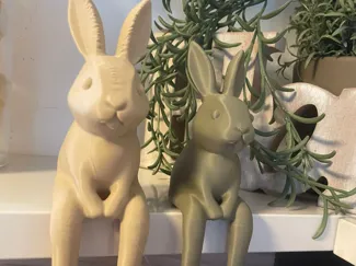 Sitzende Deko-Hasen mit baumelnden Beinen