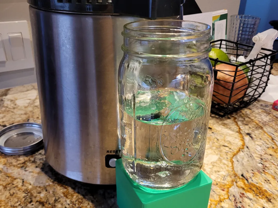 Mason jar stand positioned under an Air Still spout