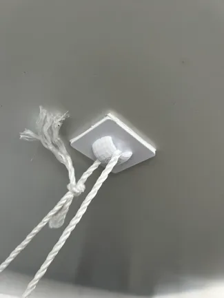 Strong ceiling loop for hanging decorations from smooth surfaces using sticky tabs