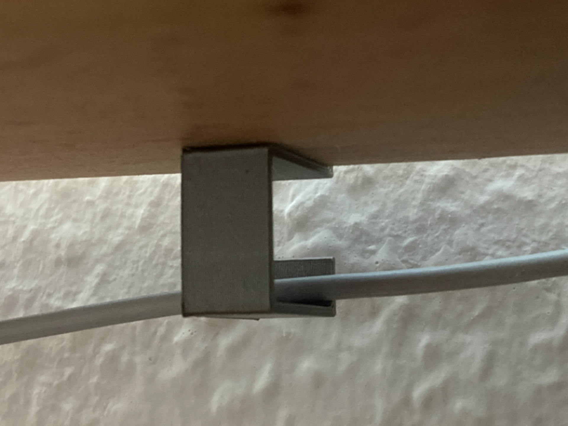 Adjustable cable holder for the edge of a desk
