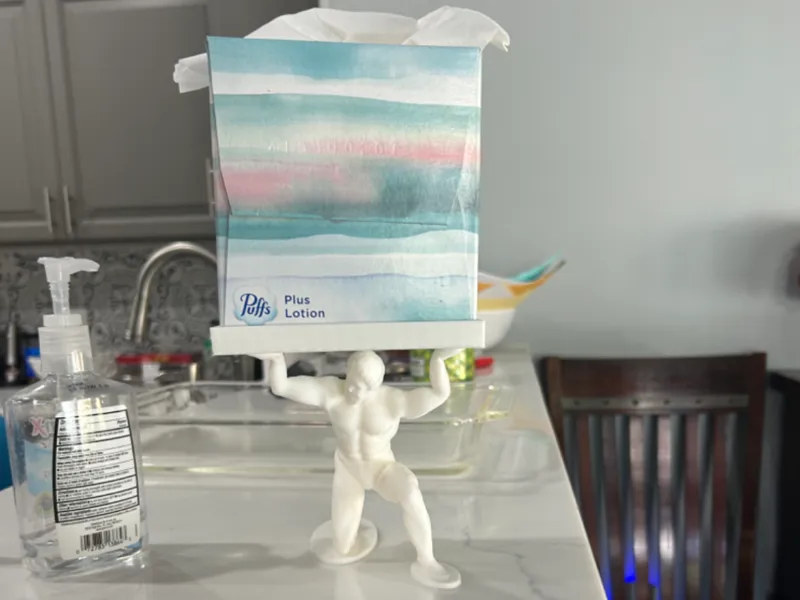 Atlas holding tissue box