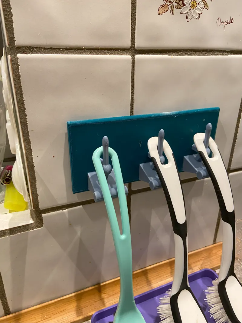 Brush hanger for kitchen sink wall