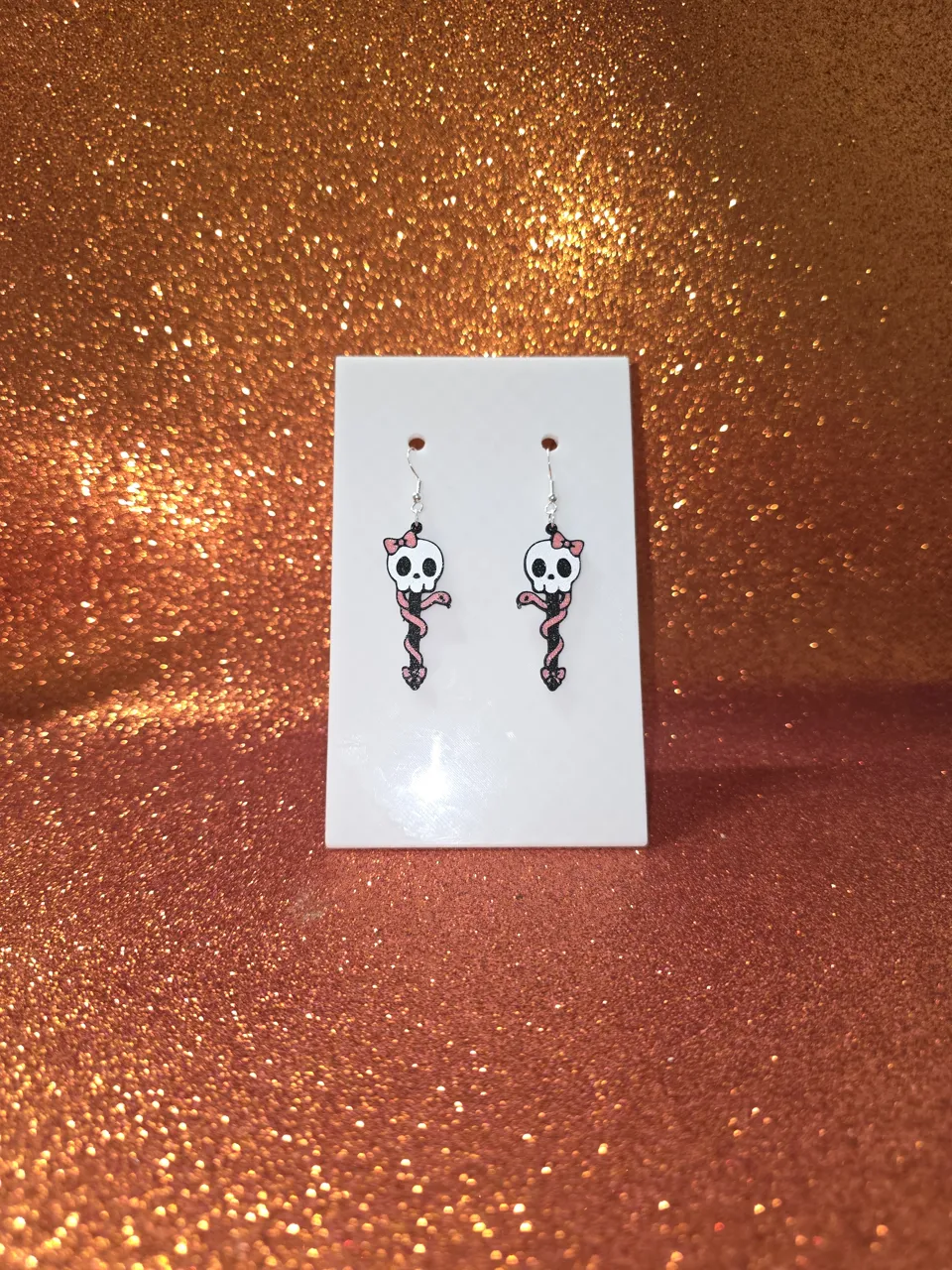 Skull and snake charm with bows earrings view 2