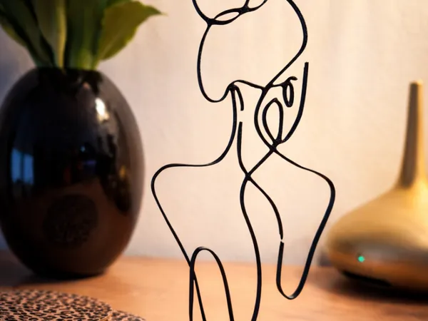 Silhouette femme assise — art en une ligne