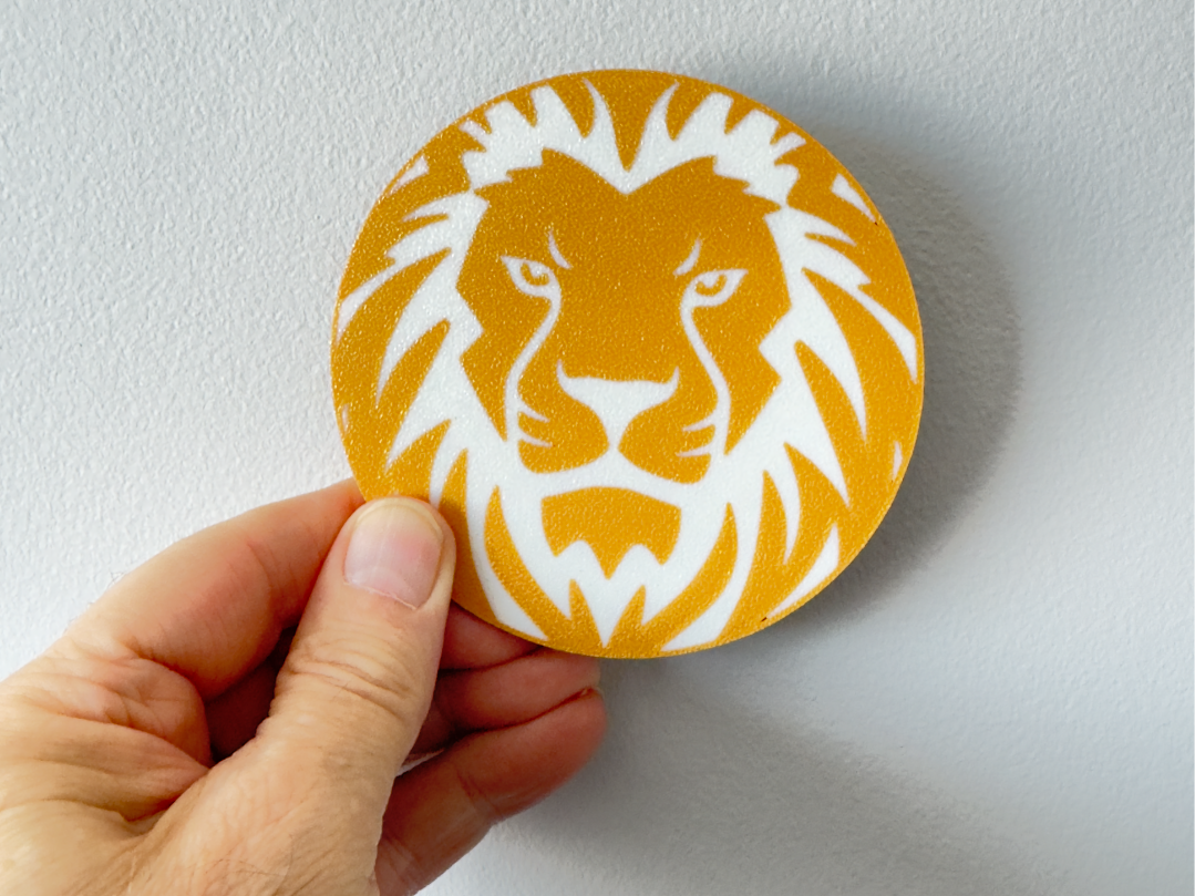 A bold two-colour lion face coaster 