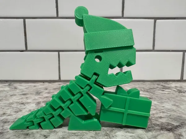 Dino articulé de Noël avec bonnet et cadeau