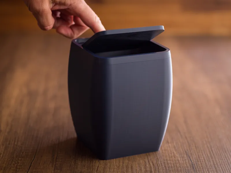 Desktop trash bin with lid.