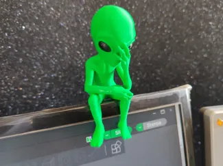 Alieno triste seduto sul monitor