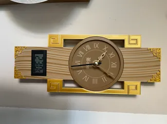 Moderne Wanduhr mit goldfarbenen Applikationen