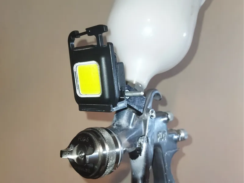 Flashlight mount for spray gun.