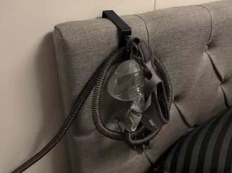 Holder for CPAP mask to hang on bed headboard