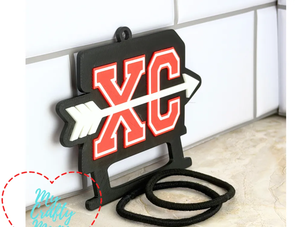 Accesorio para sujetar ligas de cabello: Cross Country Hair Tie keychain XC. Referencia del modelo original.