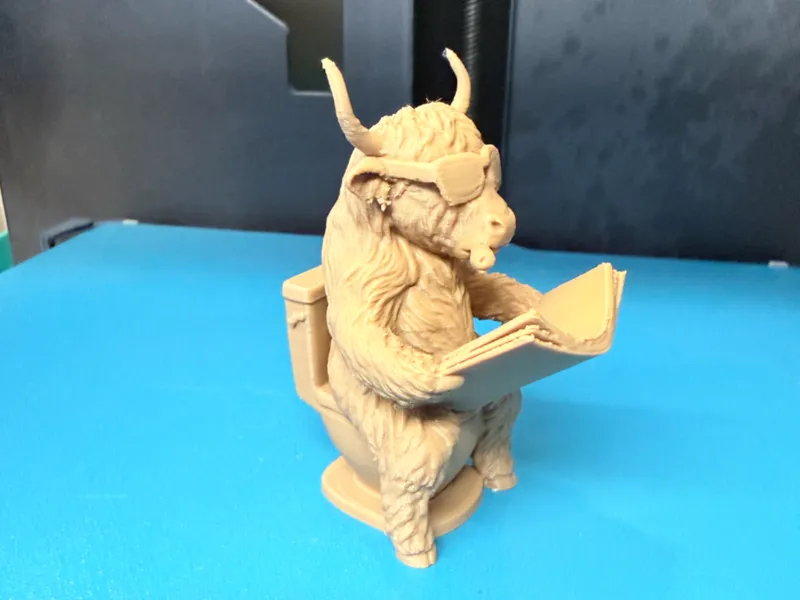 Highland Cow Reading on Toilet