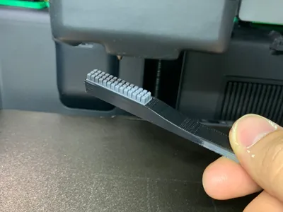 Nozzle brush handle with nozzle wiper