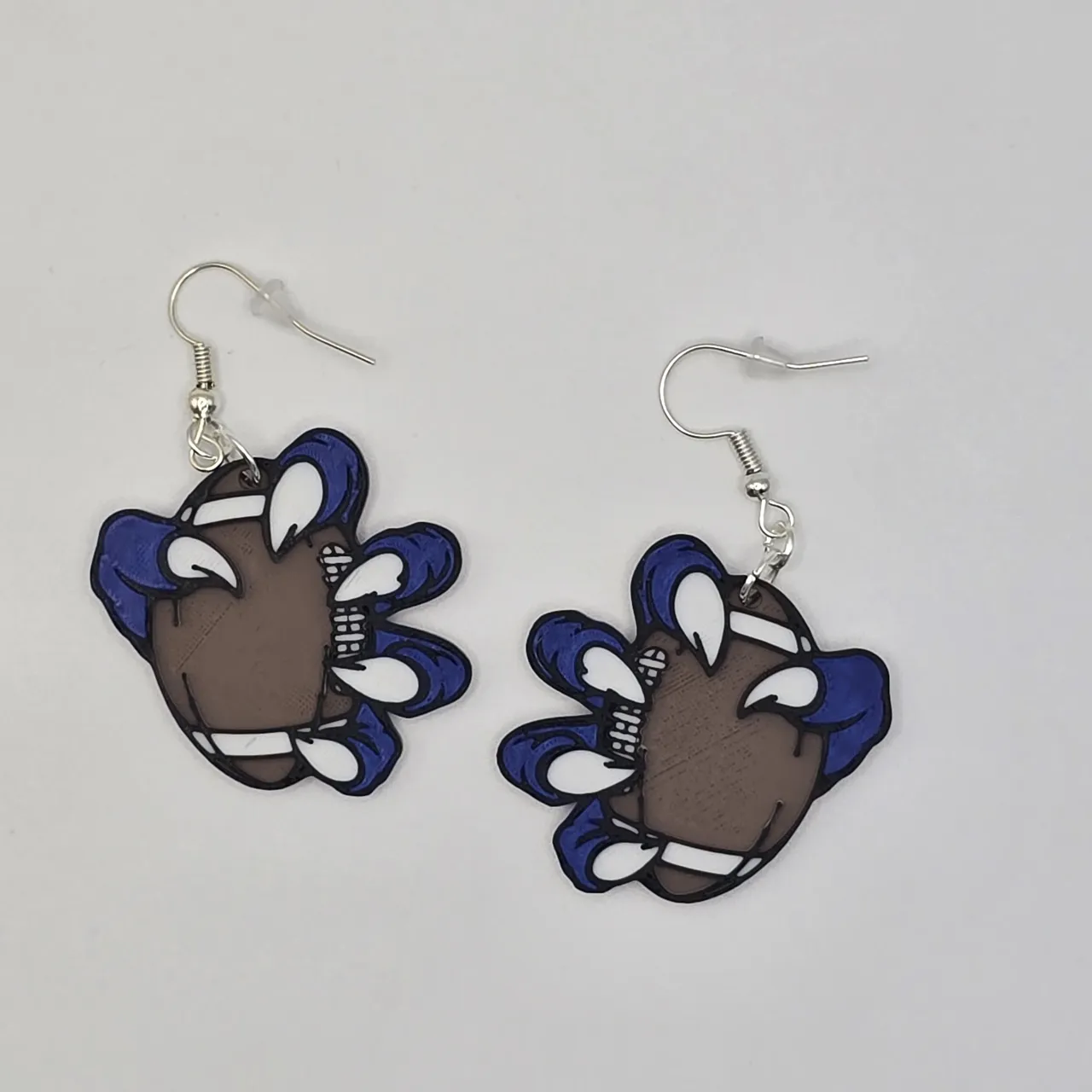 Monster claw holding football earrings view 4