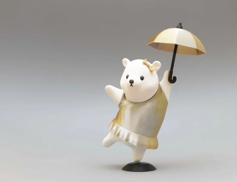 Cute figure of bear girl dancing with umbrella