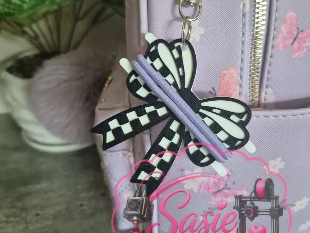 Accesorio para sujetar ligas de cabello: Checkered Bow Hair Tie Holder Keychain. Referencia del modelo original.