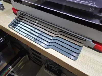 Print bed shelves with HULA dampening feet, featuring 10mm stepped, 5mm stepped, and stepless versions, designed for modular assembly