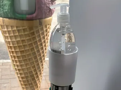 Hand sanitizer holder for retractable barrier