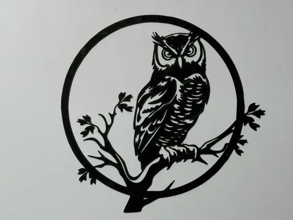 Silhouette ronde d'un hibou sur une branche
