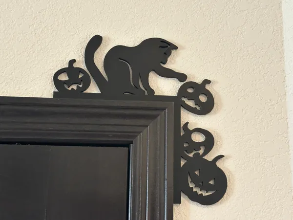 Coin de porte chat poussant des citrouilles