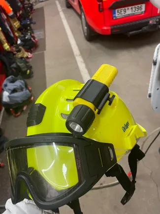 Flashlight holder for a fireman's helmet