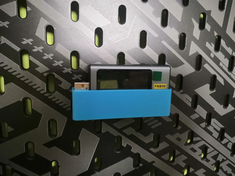 Holder for FNIRSI FNB58 on a Skadis board.