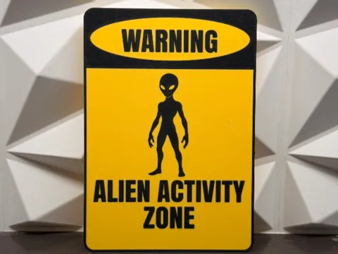 Letrero o emblema decorativo: cartel alien activity zone — referencia de MakerWorld