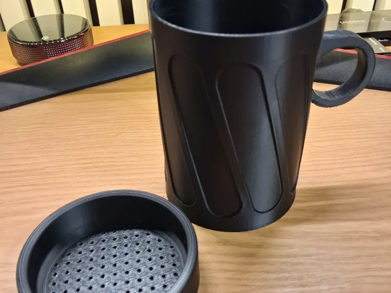 Cup with a strainer for coffee grounds