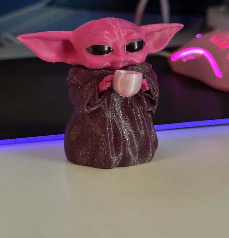 Baby yoda holding a cup 