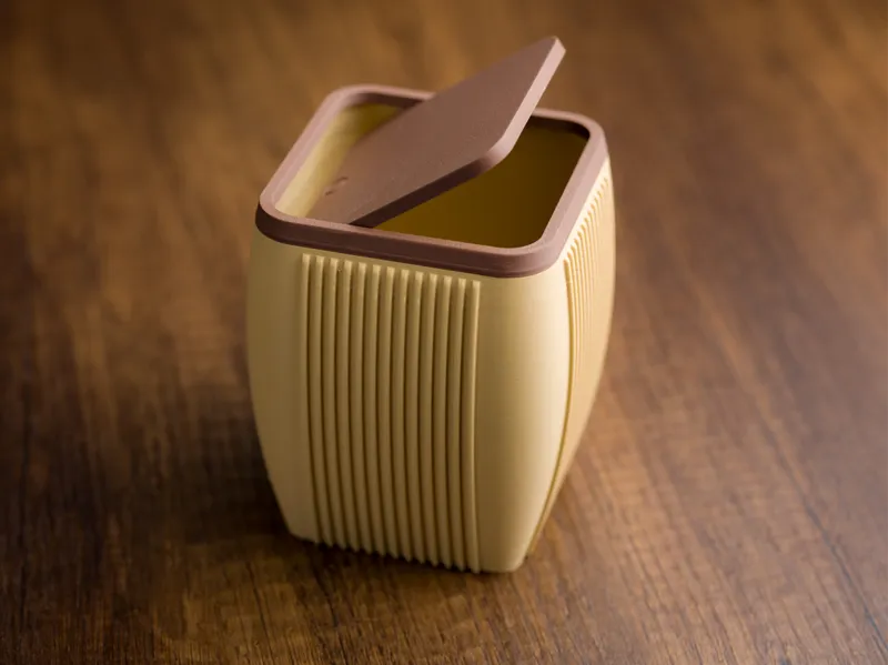 Desktop ribbed trash bin with lid.