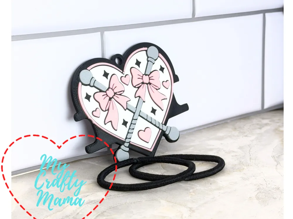 Accesorio para sujetar ligas de cabello: Batons in a heart hair tie keychain. Referencia del modelo original.