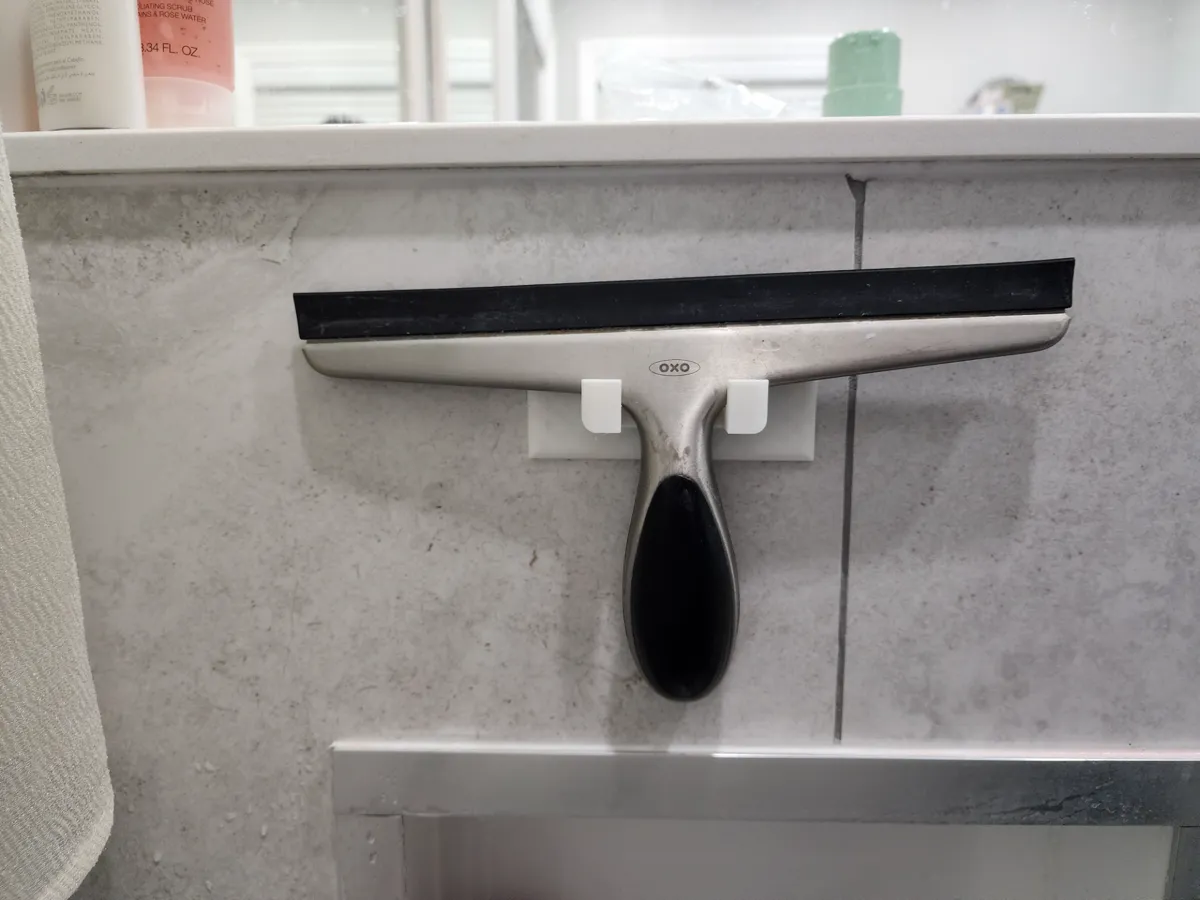Support mural pour raclette de douche