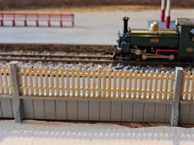 Model fence on retaining wall